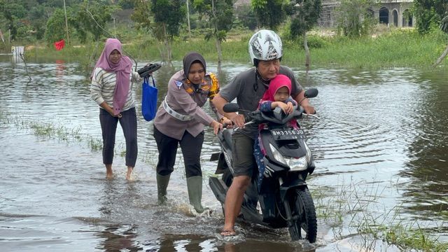 Kasatlantas AKP Akira Ceria Dorong Motor Warga yang Mogok Terendam Air